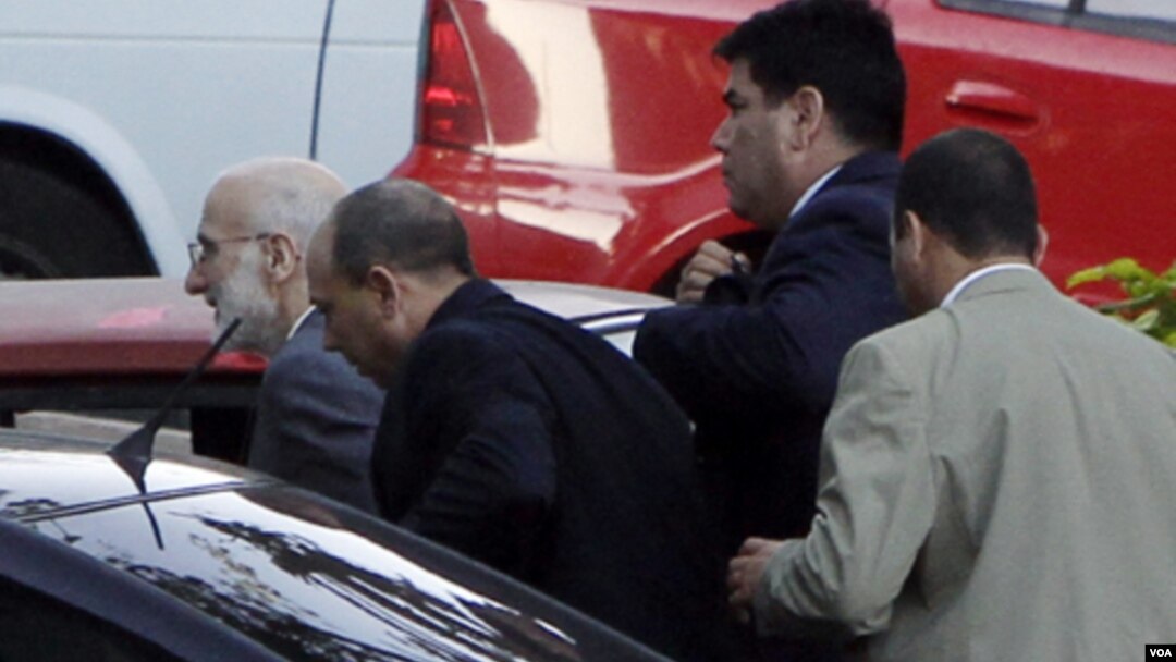 Alan Gross (izq.) cuando era llevado a juicio en marzo de 2011 por agentes de la seguridad cubana. 