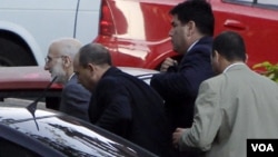 Alan Gross (izq.) cuando era llevado a juicio en marzo de 2011 por agentes de la seguridad cubana. 