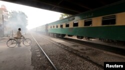 A man waits to cross a portion of track once shared with the Karachi Circular Railway line in Karachi, Pakistan, May 24, 2017.