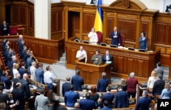 Ukrainian lawmakers sing the national anthem after a vote, in parliament, in Kiev, Ukraine,Thursday, April 25, 2019.