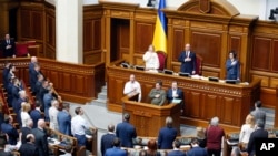 Ukrainian lawmakers sing the national anthem after a vote, in parliament, in Kyiv, Ukraine,Thursday, April 25, 2019. 