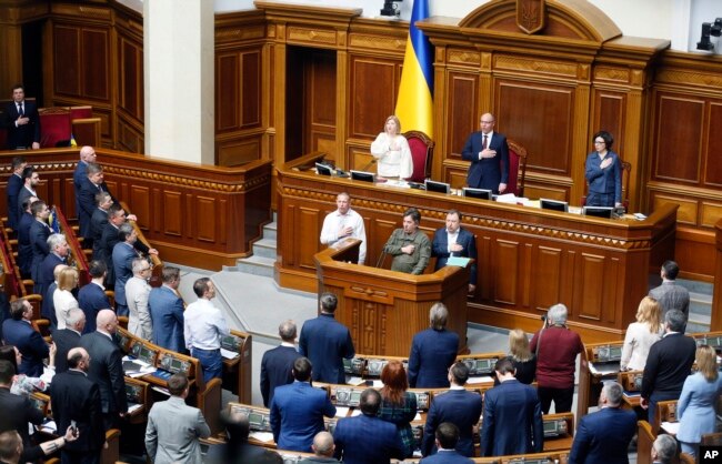 Ukrainian lawmakers sing the national anthem after a vote, in parliament, in Kiev, Ukraine,Thursday, April 25, 2019.