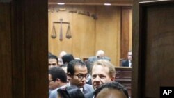 Quelques personnes se tiennent dans la salle d’audiences au tribunal pénal du Caire, Egypte, 2 mars 2016.