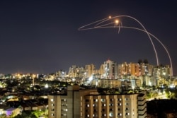 Streaks of light are seen as Israel's Iron Dome anti-missile system intercepts rockets launched from the Gaza Strip toward Israel, as seen from Ashkelon, Israel, May 14, 2021.