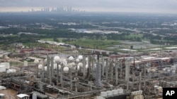FILE - The TPC petrochemical plant is shown with downtown Houston in the background, Aug. 29, 2017.