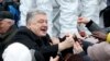 Ukrainian President Petro Poroshenko, left, greets people gathered to support an independent Ukrainian church near the St. Sophia Cathedral in Kyiv, Ukraine, Saturday, Dec. 15, 2018. 