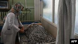 FILE - A female nurse takes care of a patient at Wazir Akbar Khan hospital in Kabul on Sept. 1, 2021. 