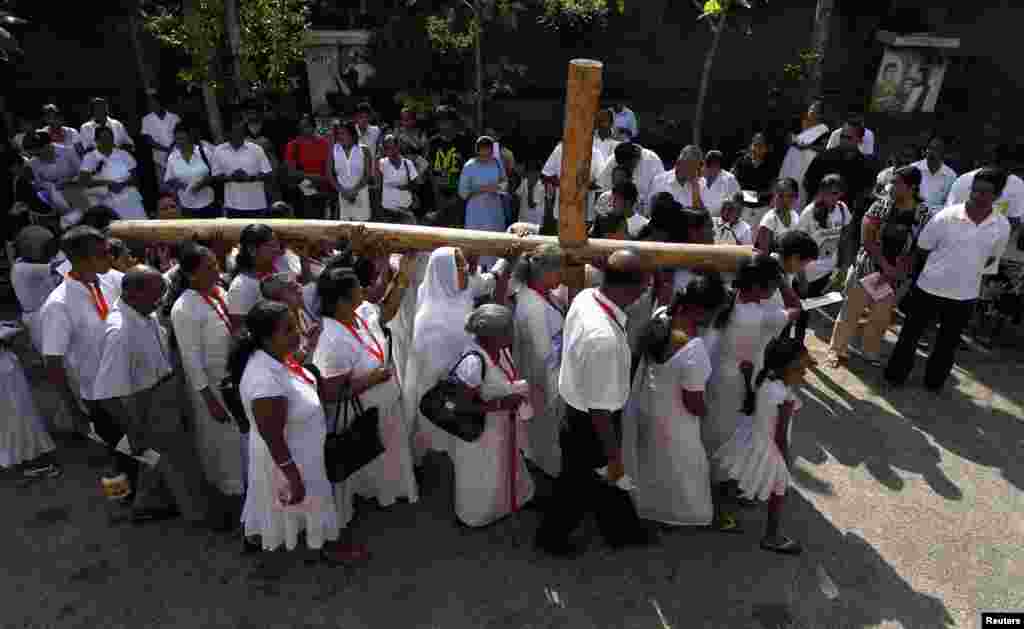 Catholics carry a cross at a street parade during a special Good Friday mass in Colombo, Sri Lanka, March 29, 2013.
