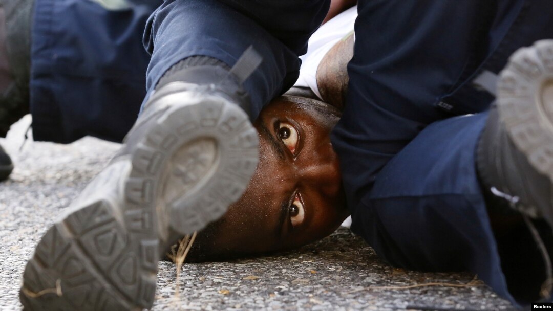 A man protesting the shooting death of Alton Sterling is detained by law enforcement near the headquarters of the Baton Rouge Police Department in Baton Rouge, Louisiana, July 9, 2016. 
