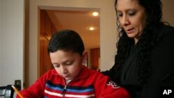 Ashton Faller doing homework with his mother last year. Ashton has received treatment for autism since he was two years old.