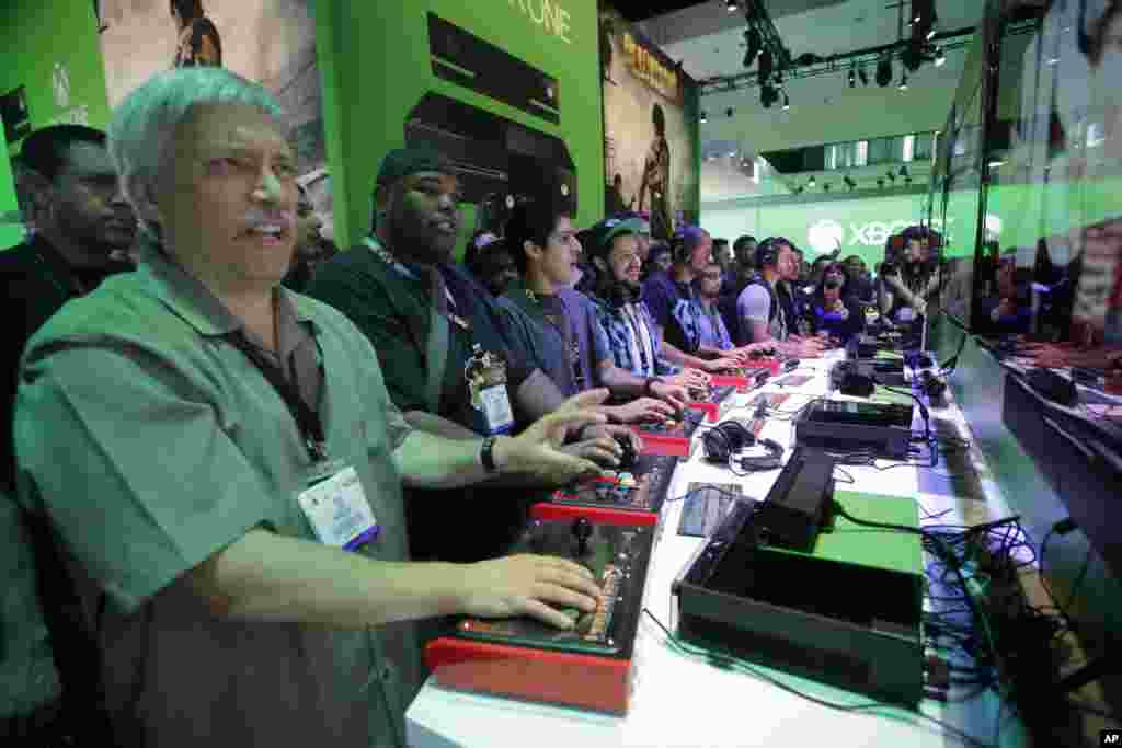 Show attendees play the Killer Instinct video game on the Xbox One at the Microsoft booth during the Electronic Entertainment Expo in Los Angeles, June 11, 2013. 