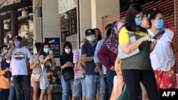 စင်ကာပူတွင် မျက်နှာဖုံးဝတ်ဆင်ပြီး ဈေးဝယ်ရန် တန်းစီနေသူများ။ (ဧပြီ ၈၊ ၂၀၂၀)