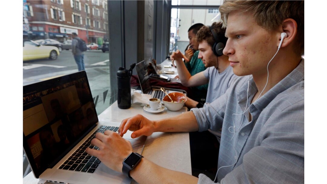 Connor Mitchell, kanan, bekerja pada komputer di sebuah kafe di San Francisco, Kamis, 13 April 2017. (Foto: AP/Ben Margot)