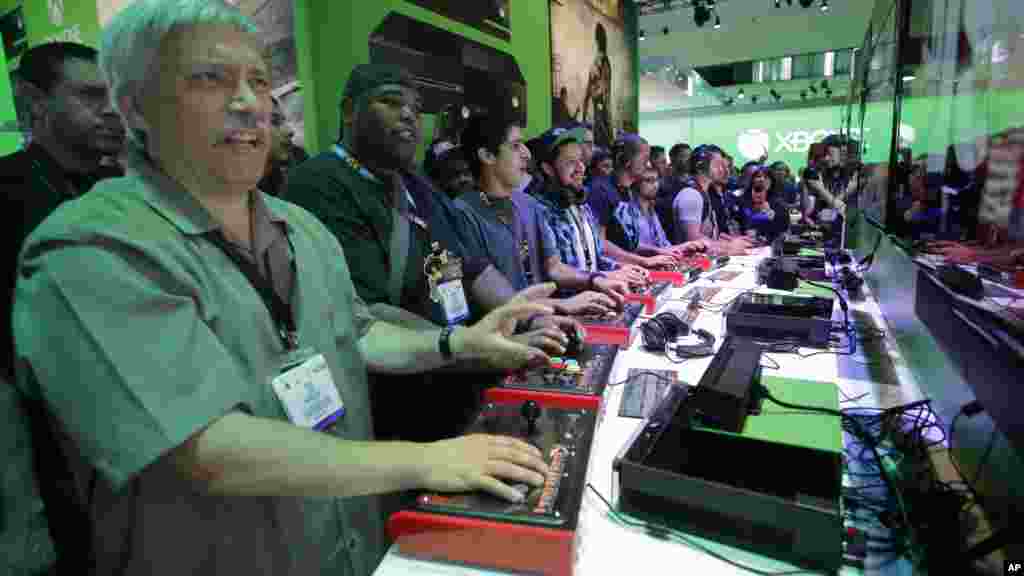 Show attendees play the Killer Instinct video game on the Xbox One at the Microsoft booth during the Electronic Entertainment Expo in Los Angeles, June 11, 2013. 