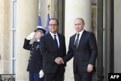 French President Francois Hollande (L) shakes hands with Russian President Vladimir Putin upon his arrival at the Elysee Palace, on Oct. 2, 2015, for a peace summit on the Ukraine conflict.