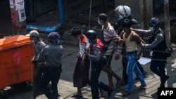 Police arrest people in Yangon on February 27, 2021, as protesters were taking part in a demonstration against the military coup. (Photo by Ye Aung THU / AFP)