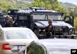 Pripadnici kosovske policije na mestu na kom su kosovski Srbi blokiraloi put, u blizini graničnig prelaza Jarinje, 20. septembra 2021. (Foto: AP, Bojan Slavković).