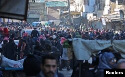 People gather to be evacuated from al-Sukkari rebel-held sector of eastern Aleppo, Syria, Dec. 15, 2016.
