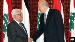Outgoing Lebanese Prime Minister Najib Mikati, right, shakes hands with Palestinian President Mahmoud Abbas, left, at the government house, in Beirut, Lebanon, July 4, 2013.
