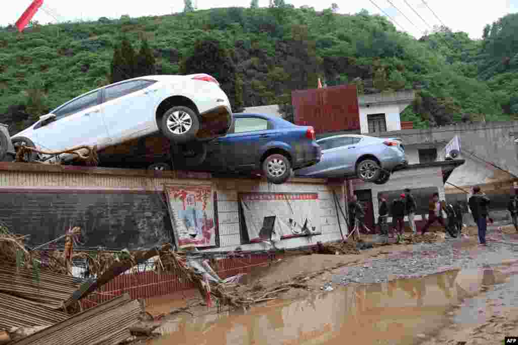 Photo shows the result of heavy storms that triggered a flood in southwest China's Yunnan province; flood waters washed cars onto a wall, May 11, 2015.