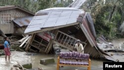 Warga membersihkan sofa di luar rumah mereka yang hancur dihantam topan Bopha di Lembah Compostela, FIlipina Selatan (5/12). 