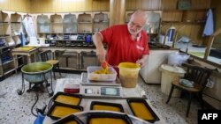 Hasan El-Makary weighs mufataka, a traditional Beiruti sweet, at his shop in the Lebanese capital on Aug. 29, 2024. 