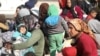 Displaced women who fled the Aleppo countryside sit with their children in Tabqa, Syria, Dec. 4, 2024.