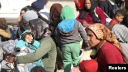 Perempuan pengungsi yang melarikan diri dari pedesaan Aleppo, duduk bersama anak-anak mereka di Tabqa, Suriah, 4 Desember 2024. (Orhan Qereman/REUTERS)