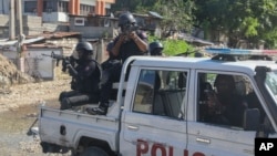 Police officers patrol an area during an exchange of gunfire between gangs and police in Port-au-Prince, Haiti, Nov. 11, 2024. 