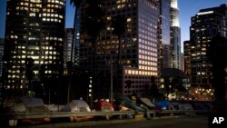Homeless tents are dwarfed by skyscrapers as 63-year-old Vincent, who gave only his first name, sorts his belongings, Dec. 1, 2017, in Los Angeles. Vincent said he never had to worry about getting a job as a young man. "Things ain't the way they were anymore." The U.S. Department on Housing and Urban Development release of the 2017 homeless numbers show a dramatic increase in the number of people lacking shelter along the West Coast.