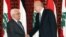 Outgoing Lebanese Prime Minister Najib Mikati, right, shakes hands with Palestinian President Mahmoud Abbas, left, at the government house, in Beirut, Lebanon, July 4, 2013.