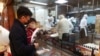 FILE - Customers wait outside of the kitchen of the Din Tai Fung restaurant in Taipei, Taiwan, Jan. 28, 2021. The chain will be closing more than a dozen stores in China.