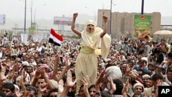 A girl stands above the crowd as anti-government protesters shout slogans during a rally to demand the ouster of Yemen's President Ali Abdullah Saleh on the first Friday of the month of Ramadan in Sana'a, August 5, 2011