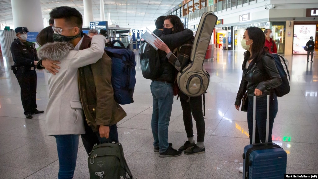 资料照片：2020年3月28日星期六，被驱逐的《华尔街日报》记者在离开北京前拥抱同事。(photo:VOA)