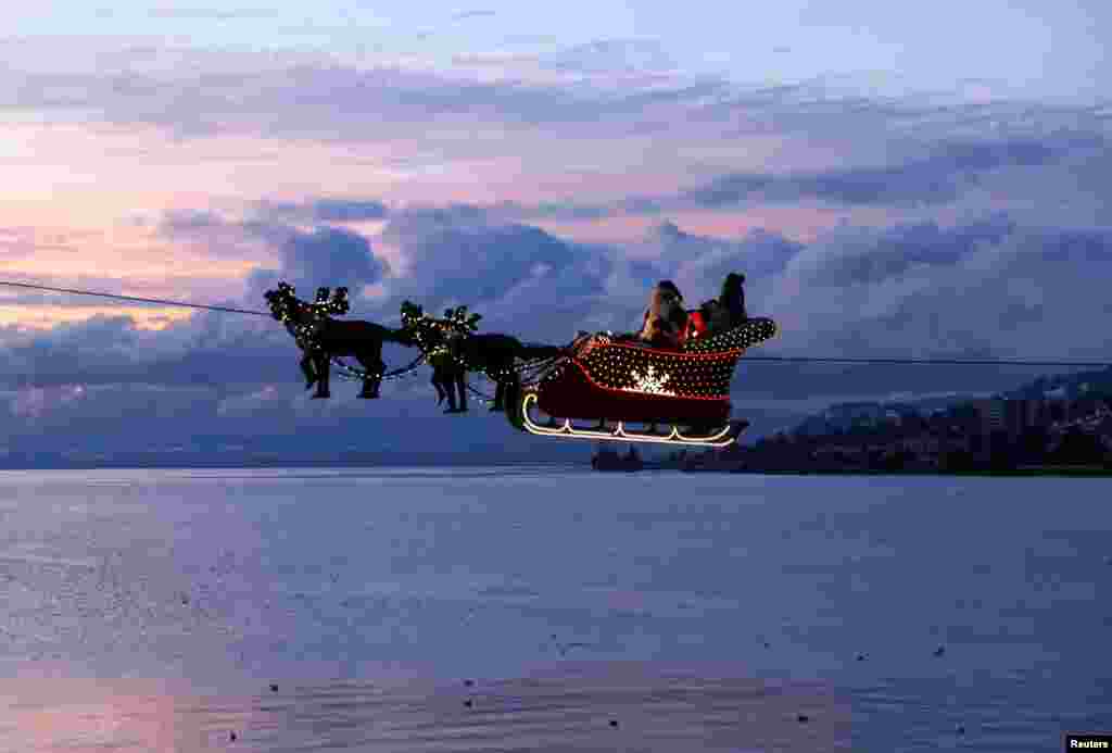 Saint Nicholas and his reindeers fly above Lake Leman at the Christmas Market in Montreux, Switzerland.