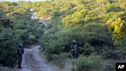 Mexican marines guard the area where new clandestine mass graves were found on the ouskisrts of Cocula, Mexico, Oct. 27, 2014. 