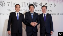 Chinese Premier Li Keqiang, left, Japanese Prime Minister Shinzo Abe, center, and South Korean President Moon Jae-in, right, pose for photographers before their summit in Tokyo, May 9, 2018.