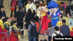 한국관광공사 중국팀 직원들이 25일 중국 국경절(10월 1∼7일) 연휴를 앞두고 인천공항을 통해 방한하는 중국인 관광객들을 환대하고 있다.