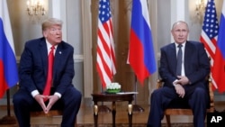 FILE - U.S. President Donald Trump, left, and Russian President Vladimir Putin, right, listen to the media in Helsinki, Finland, July 16, 2018. Trump said on Tuesday he would likely impose sanctions on Russia if Putin refuses to negotiate about ending the war in Ukraine. 