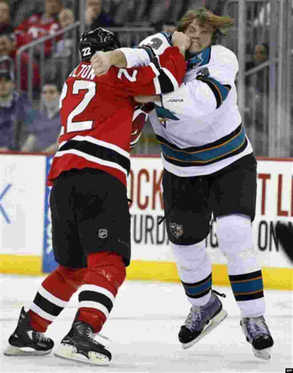 New Jersey Devils' Eric Boulton (22), of Canada, knocks San Jose Sharks' Douglas Murray (3) off his skates as they fight during the first period of an NHL hockey game Friday, Oct. 21, 2011, in Newark, N.J. (AP Photo/Mel Evans)