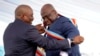 Congolese President Felix Tshisekedi, right, receives the presidential sash from outgoing president Joseph Kabila after being sworn in in Kinshasa, Democratic Republic of the Congo, Thursday Jan. 24, 2019.