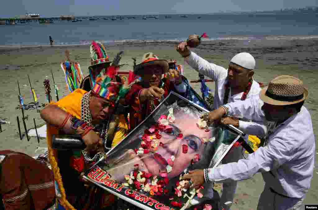 Para dukun asal Peru dengan mengangkat poster kandidat presiden AS asal Partai Demokrat, Hillary Clinton, melakukan ritual di Lima, Peru, sebelum pelaksanaan pemilihan presiden AS.