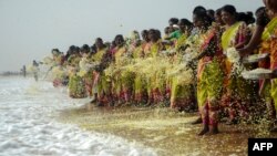 2016年12月26日印度在钦奈的马里纳海滩举行仪式纪念2004年海啸遇难者，印度妇女在仪式中向海上洒下花瓣悼念死难者。