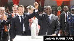 Le président ivoirien Alassane Ouattara et son homologue français Emmanuel Macron participent à une cérémonie de pose de la première brique du futur marché de Bouaké, le 22 décembre 2019, à Bouaké, en Côte d'Ivoire.