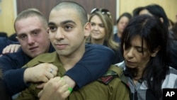 Israeli solider, Sgt. Elor Azaria, waits with family members for the verdict inside a military court in Tel Aviv, Israel on Jan. 4, 2017. 