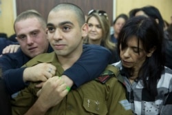 FILE - Israeli solider Sgt. Elor Azaria waits with his parents for the verdict inside the military court in Tel Aviv, Israel on Jan. 4, 2017.
