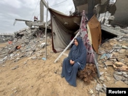 Palestinka sjedi u blizini ruševina kuće uništene tokom izraelske vojne ofanzive, u Khan Younisu.