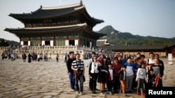FILE - Chinese tourists pose for a group photo at the Gyeongbok Palace in central Seoul, South Korea, Oct. 5, 2016. The number of Chinese tourists visiting South Korea fell 20 percent in March.
