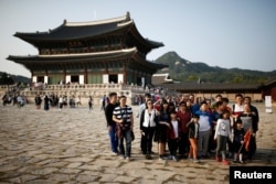 FILE - Chinese tourists pose for a group photo at the Gyeongbok Palace in central Seoul, South Korea, Oct. 5, 2016. About 8 million Chinese tourists have visited South Korea in the last five years.