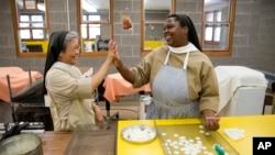 Poor Clares nuns Sister Maria Eden, left, and Sister Thereza share a laugh as they make altar bread also known as communion wafers, Sept. 8, 2015, at the Monastery of Saint Clare in Langhorne, Pa.